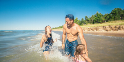 LOCATION: GRAND BEND, ON Father and two daughters playing in the water near Grand Bend