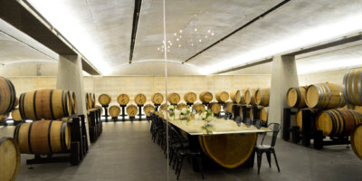 Large dining table surrounded by casks of wine at Dark Horse Estate Winery