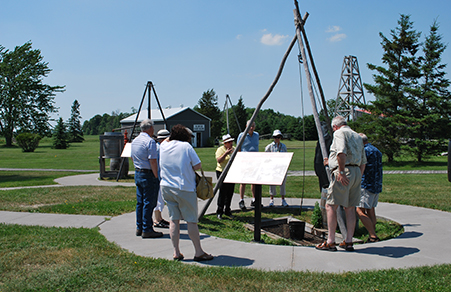 People gathered around an outdoor display at the Oil Museum of Canada