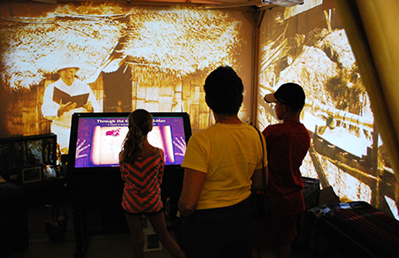 children gathered around a virtual museum exhibit