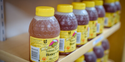Plastic jars of honey on a shelf from Munro Honey