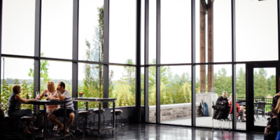 people eating beside tall glass windows at Dark Horse Estate Winery