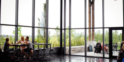people eating beside tall glass windows at Dark Horse Estate Winery
