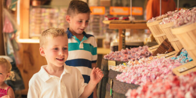 LOCATION: GRAND BEND, ON Children smiling as they walk by barrels full of candy in a store in Grand Bend