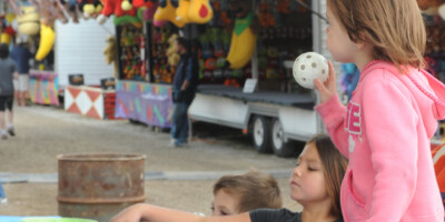 Children playing a ball toss game at the Brigden Fair