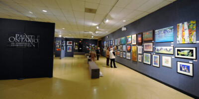 Group of people looking at artwork hanging at the Lambton Heritage Museum