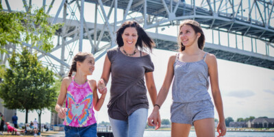 Mother and two daughters walking under the bluewater bridge