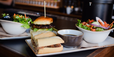 Sandwiches and burgers with garden salads on a restaurant table